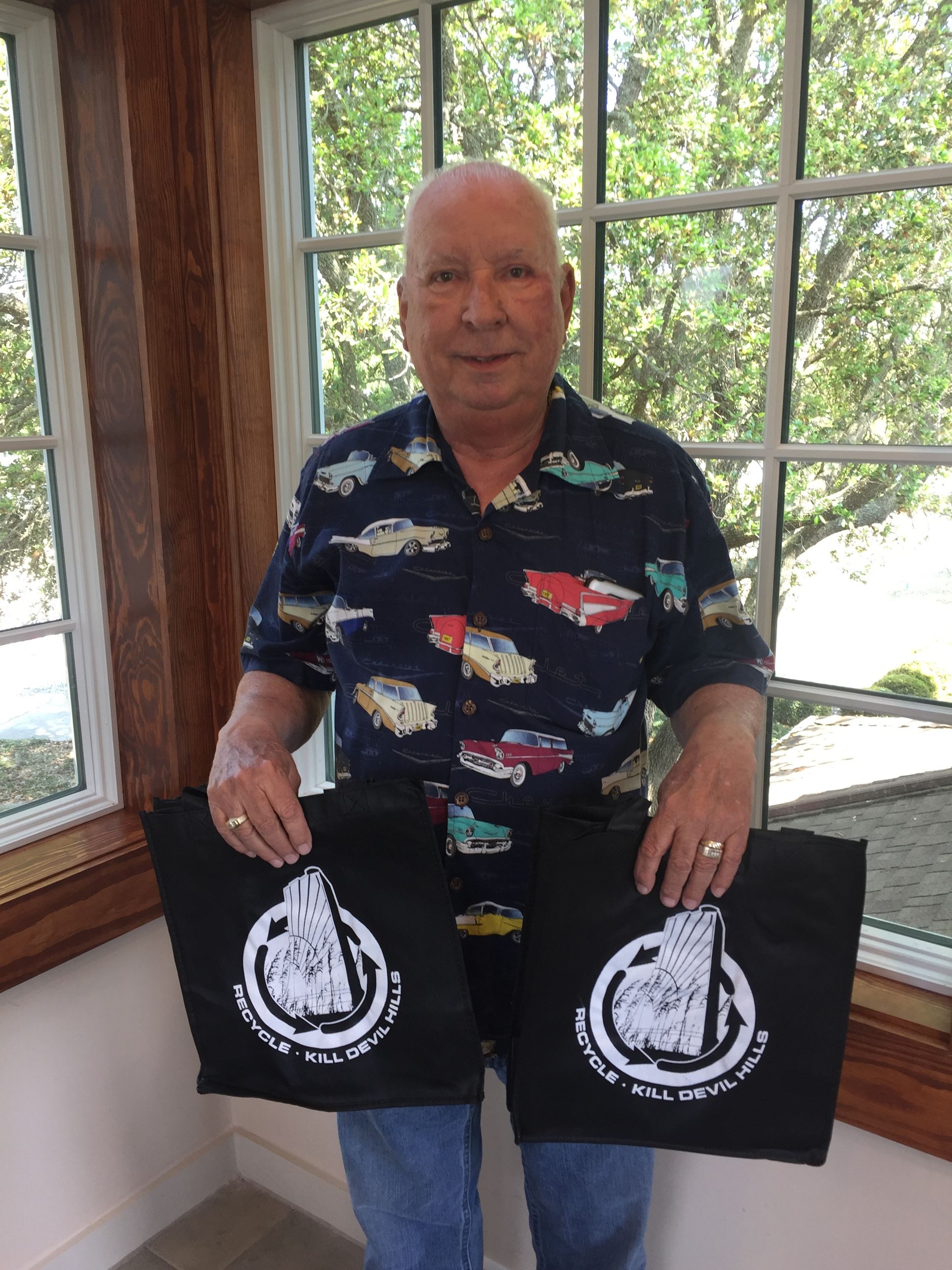 A member of the Community Appearance holds reusable bags to promote Bag Smarter Campaign 